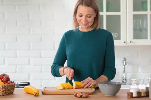 Frau schneidet Gemüse 