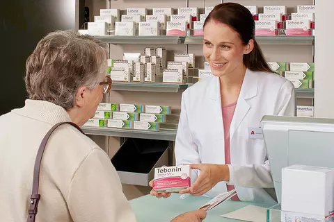 Eine ältere Kundin lässt sich in einer Apotheke zu Tebonin® beraten.