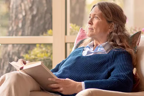 Frau liest ein Buch und macht sich Gedanken welche Ursachen Ihre Vergesslichkeit haben