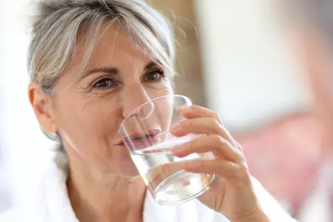 Ältere Dame trinkt Wasser aus einem Glas