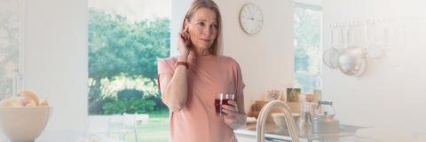 Frau drückt Zeigefinger aufs Ohr