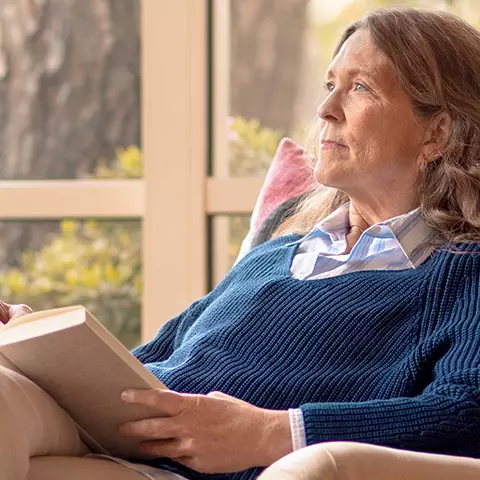 Frau liest ein Buch und macht sich Gedanken welche Ursachen Ihre Vergesslichkeit haben